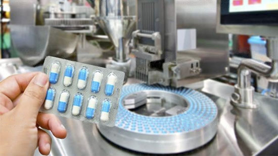 hand holding a blister with capsules on the background of an automatic capsule machine (pharmaceutical industry)
